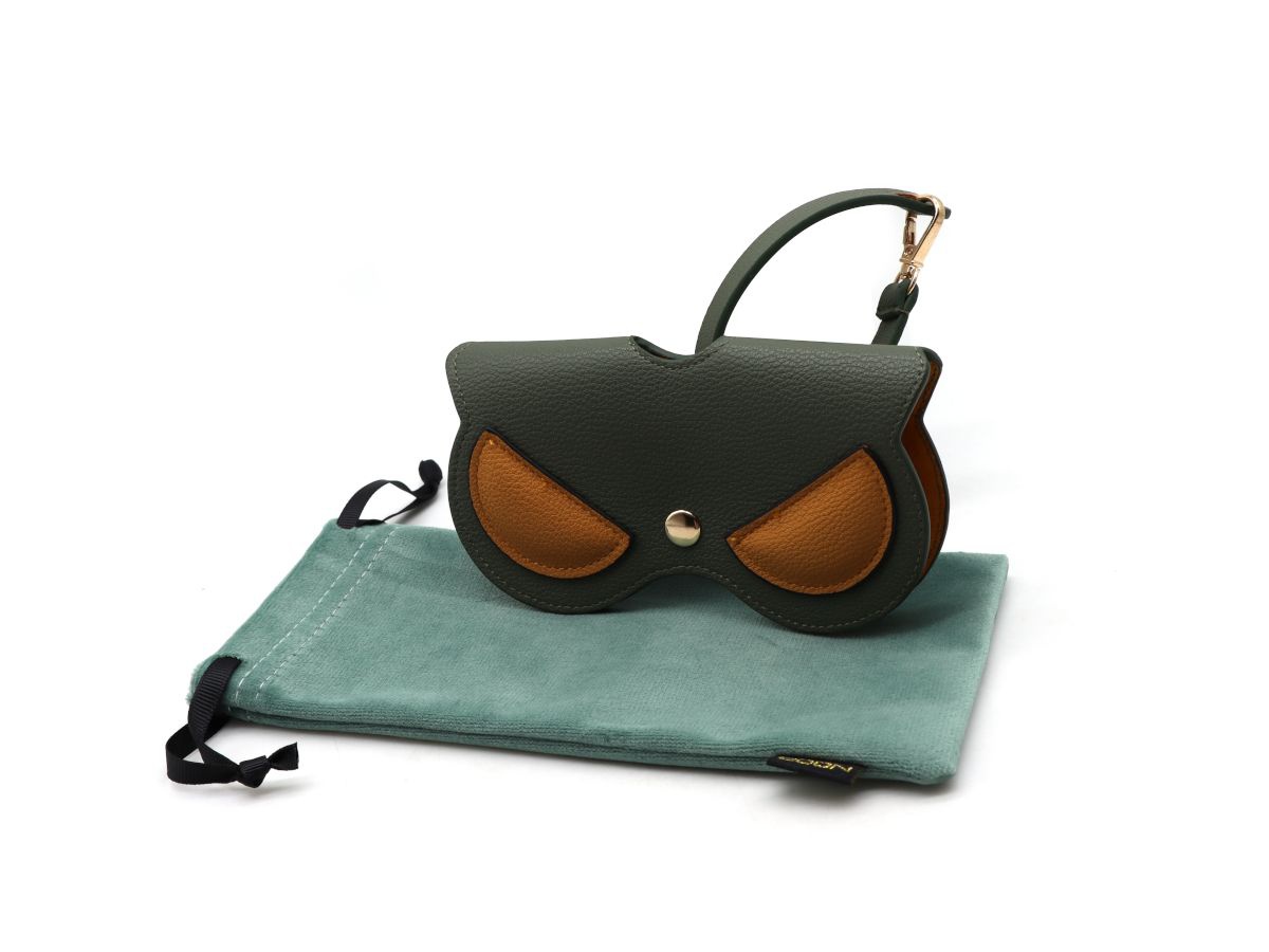 This charming sunglasses case features a whimsical owl design set against a rich green background with warm cinnamon accents. Its sturdy exterior protects your eyewear from scratches and bumps, while the soft interior lining keeps lenses safe and smudge-free. Compact and travel-friendly, it combines playful style with practical protection for everyday use.